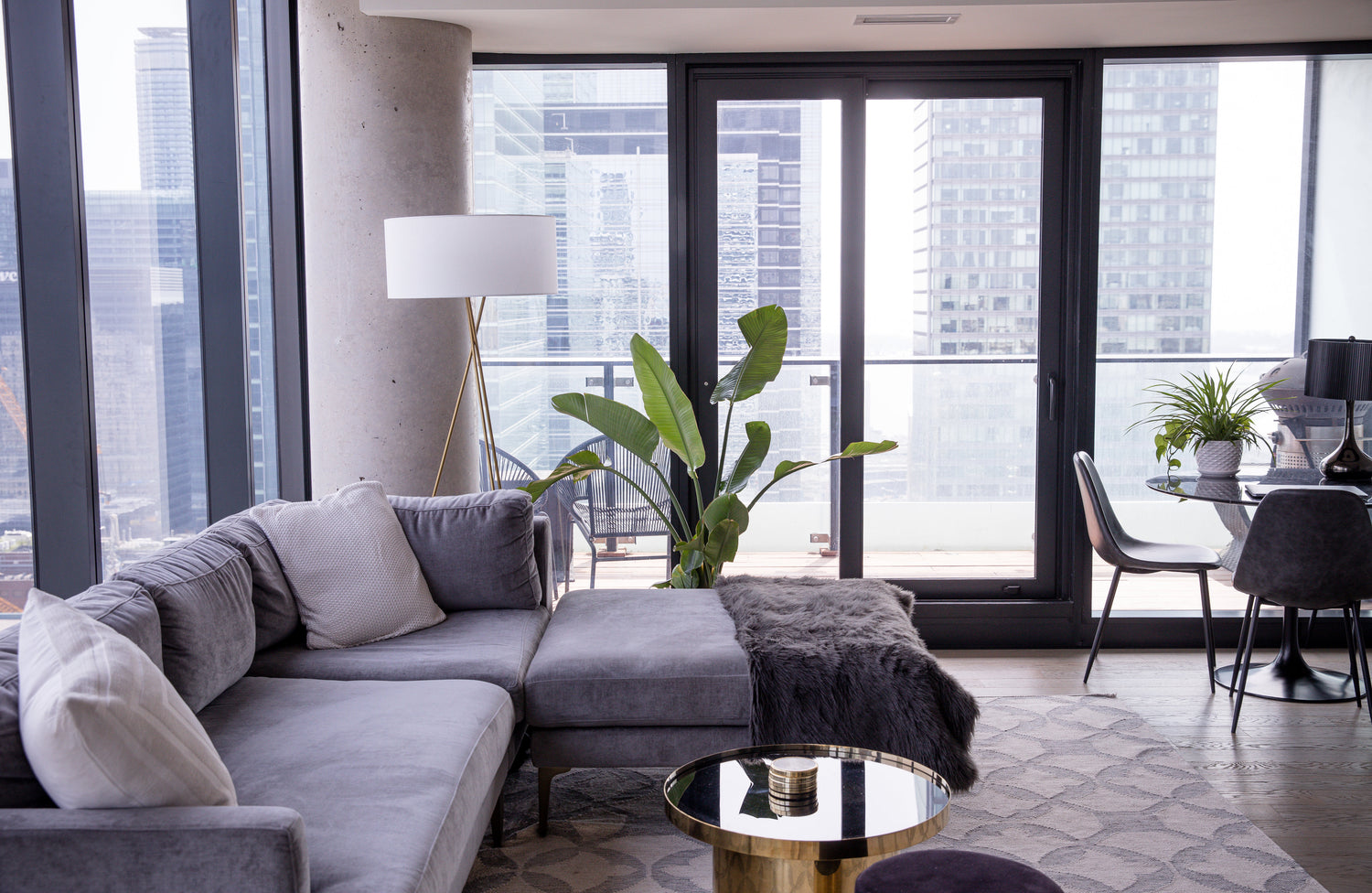 Grey tufted couch with teal velvet pillows